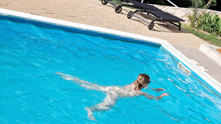 Frau nackt am Pool
