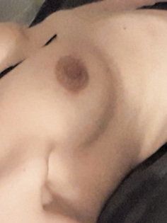 Mit freien Brüsten auf dem Sofa